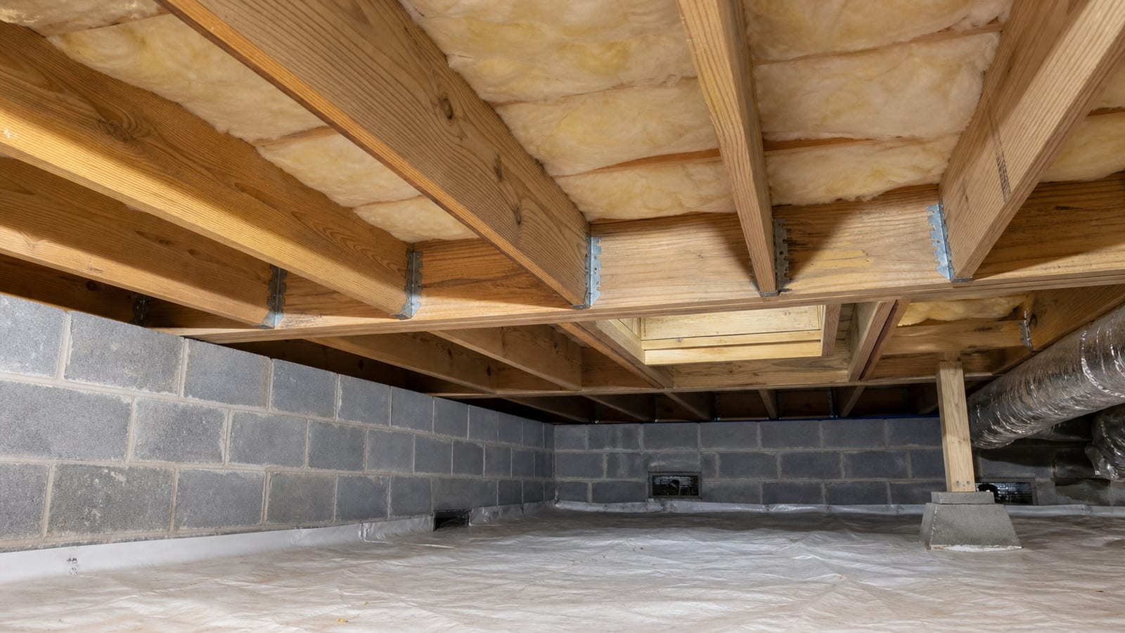 Crawl space floor framing and insulation viewed from an accessible inspection path
