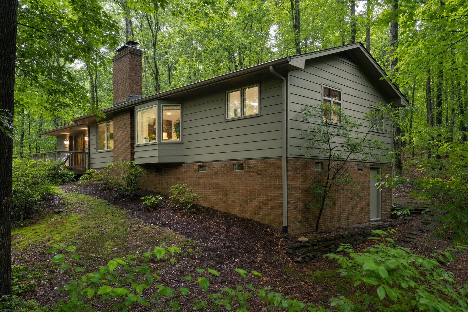 Wooded sloped-lot home with a brick crawl space foundation after rain