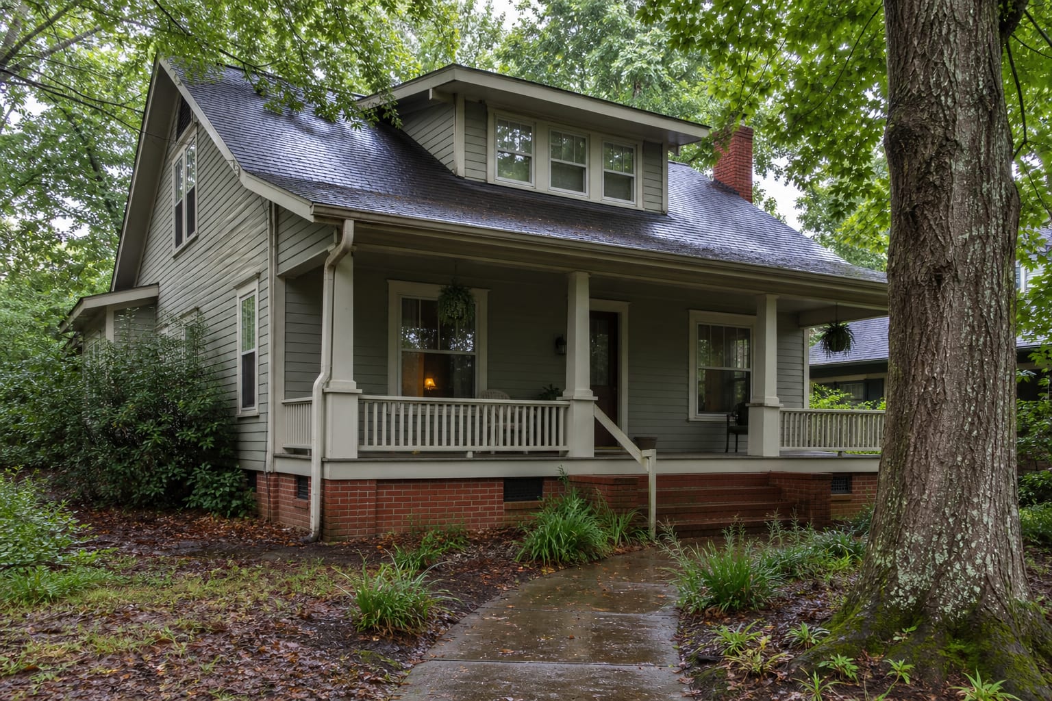 Older bungalow with a vented brick crawl space foundation beneath mature shade trees